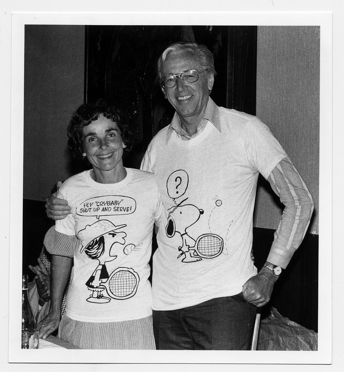 テニスのシーンがあしらわれた「ピーナッツ」のTシャツを着るシュルツ夫妻。