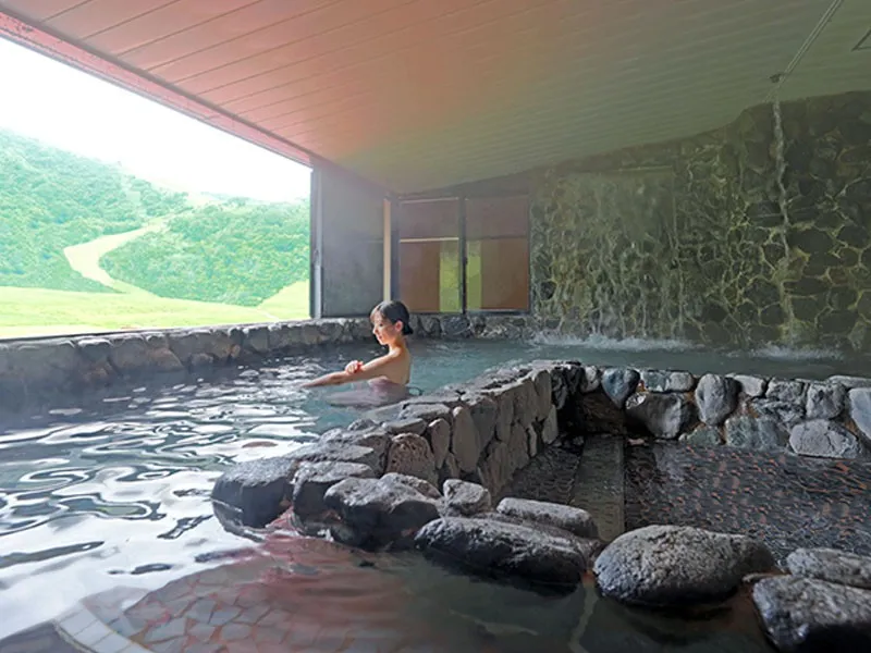 山並みを望む露天風呂でくつろぐ女性