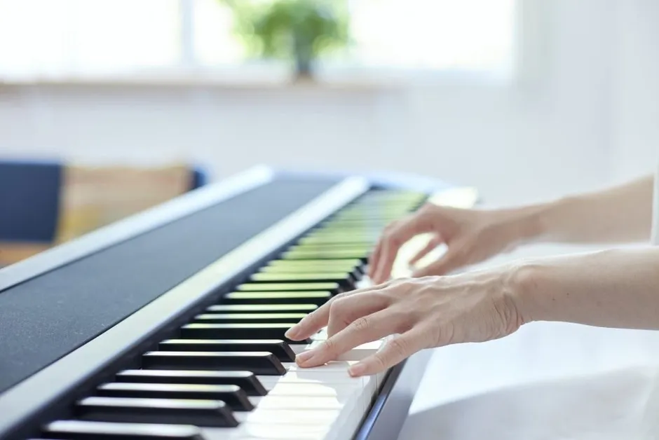 明るい室内で電子ピアノを弾く手元