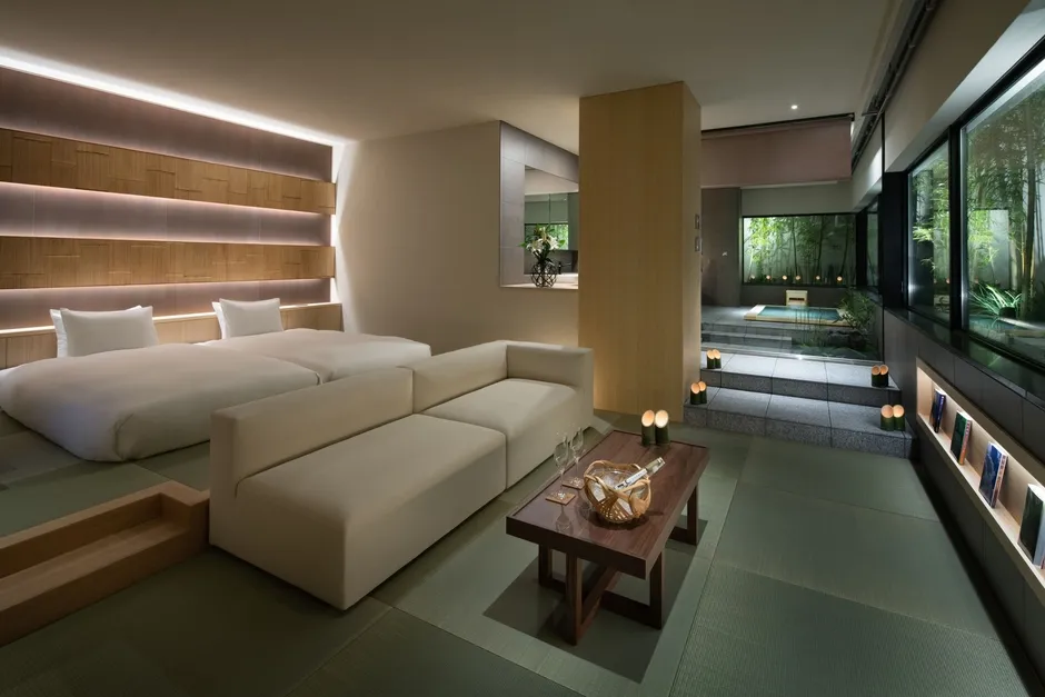 畳敷きの客室にロータイプベッドとソファ、奥に半露天風呂エリアが見えるTHE JUNEI HOTEL 京都 御所西の客室