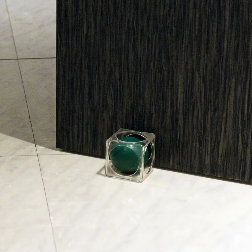 木目調ドアの足元で深緑のドアキューブを使用している様子