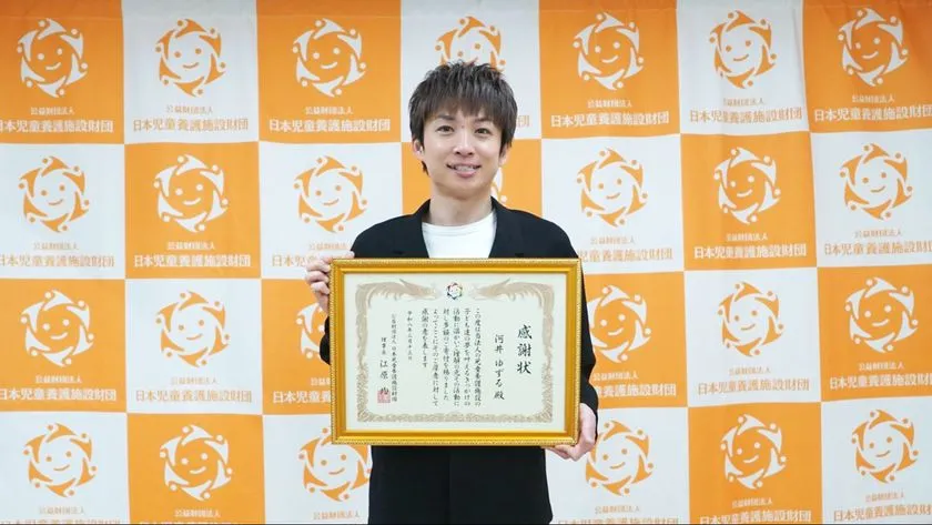 感謝状を手に笑顔を見せる河井ゆずるさん