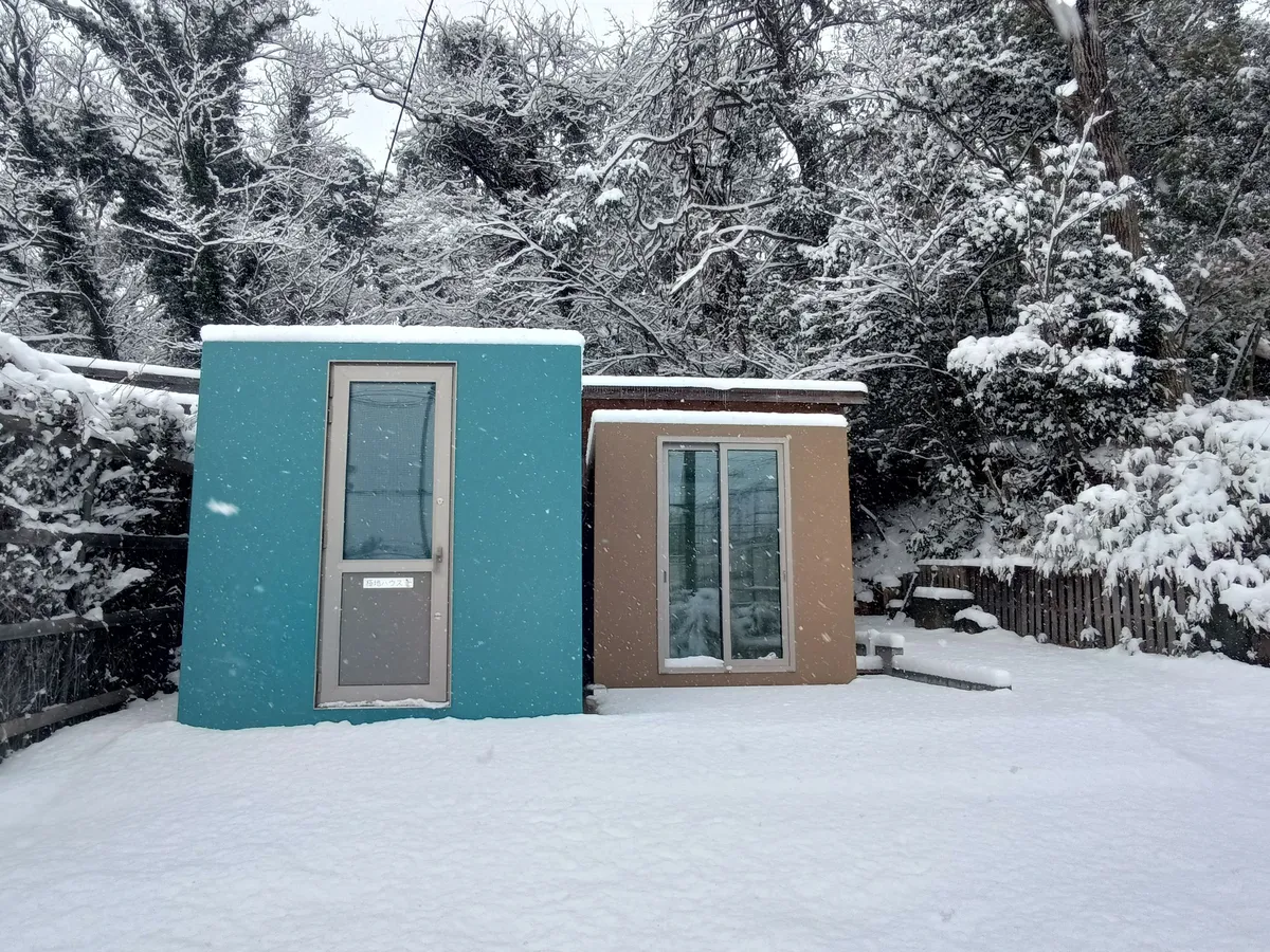 マイナス50度の知見で迅速設営・高断熱・省エネ運用を実現！明和土木興業「極地ハウス LIFT」 降雪下での極地ハウス外観と断熱空間イメージ