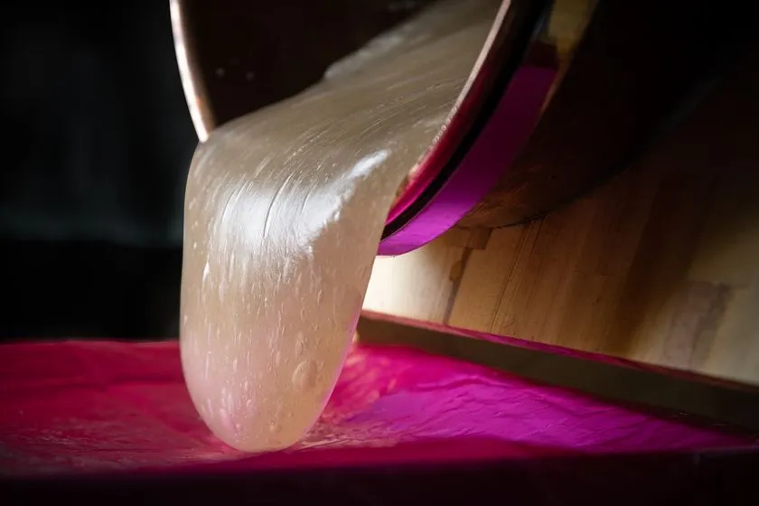 銅鍋からとろりと流れ落ちるわらび餅の生地