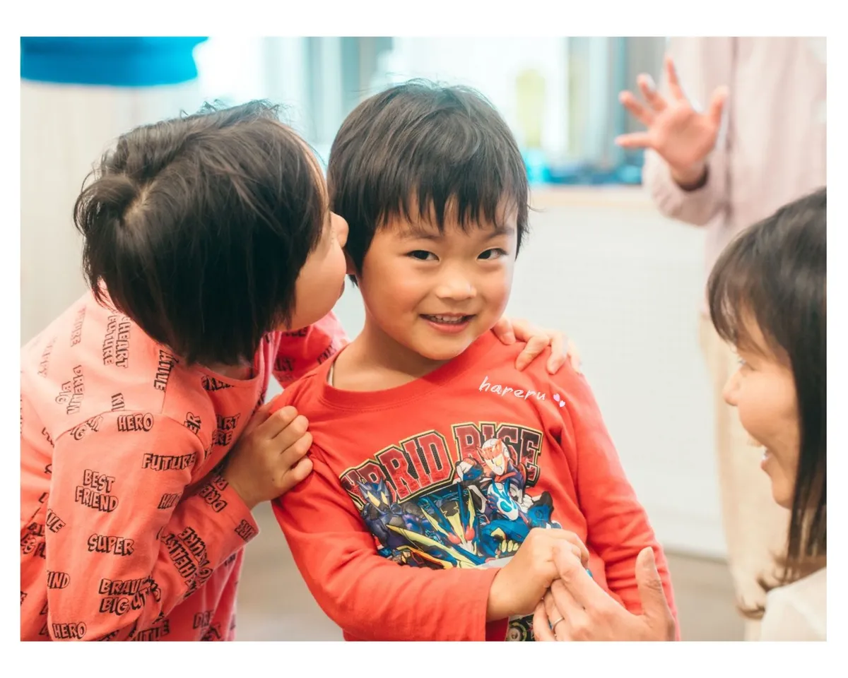 表現教育プログラム中の園児2人と講師のふれあいシーン