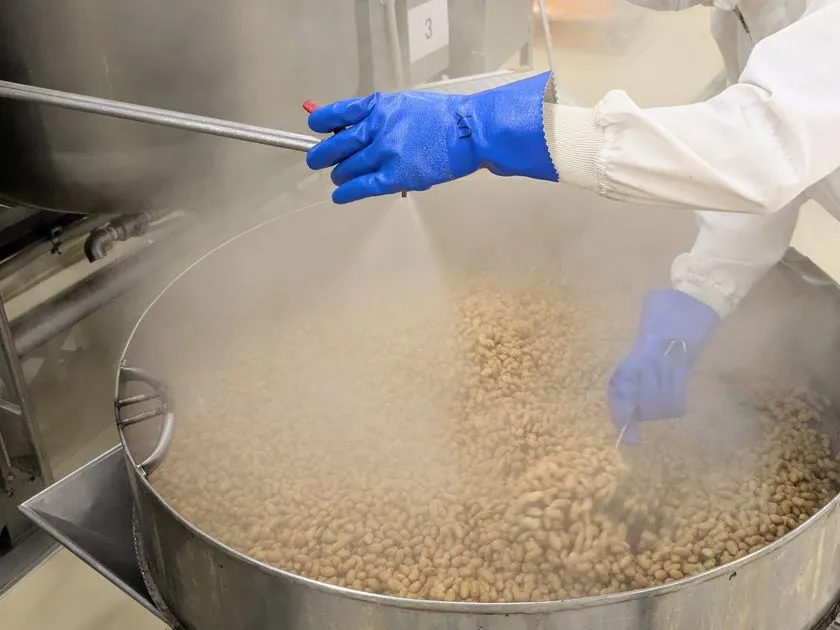 職人が納豆菌を吹き付ける製造工程