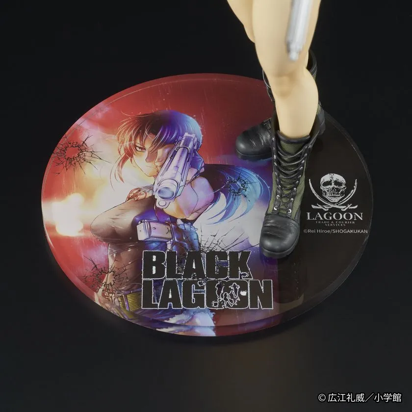 フィギュア台座のクローズアップ。円形台座にBLACK LAGOONロゴとレヴィの原作カラーイラストがプリントされ、LAGOONロゴとコンバットブーツ足元が写っている