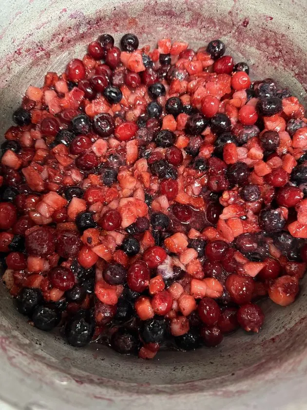 ORBIS BLUE の製造工程写真。青いシュークリームに使うベリー類のフィリング素材を鍋で仕込む様子が具体的にわかる画像。