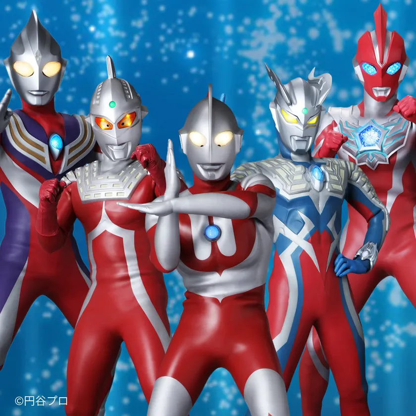 ウルトラマンティガ・ウルトラマン・ウルトラマンゼット・ウルトラマンデッカーら5体のウルトラマンが青背景でポーズをとるキャラクター集合写真（©円谷プロ）