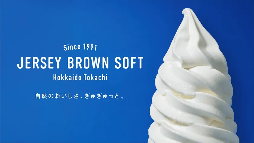 十勝の緑豊かな牧場を背景にしたジャージーブラウンソフトのイメージビジュアル
