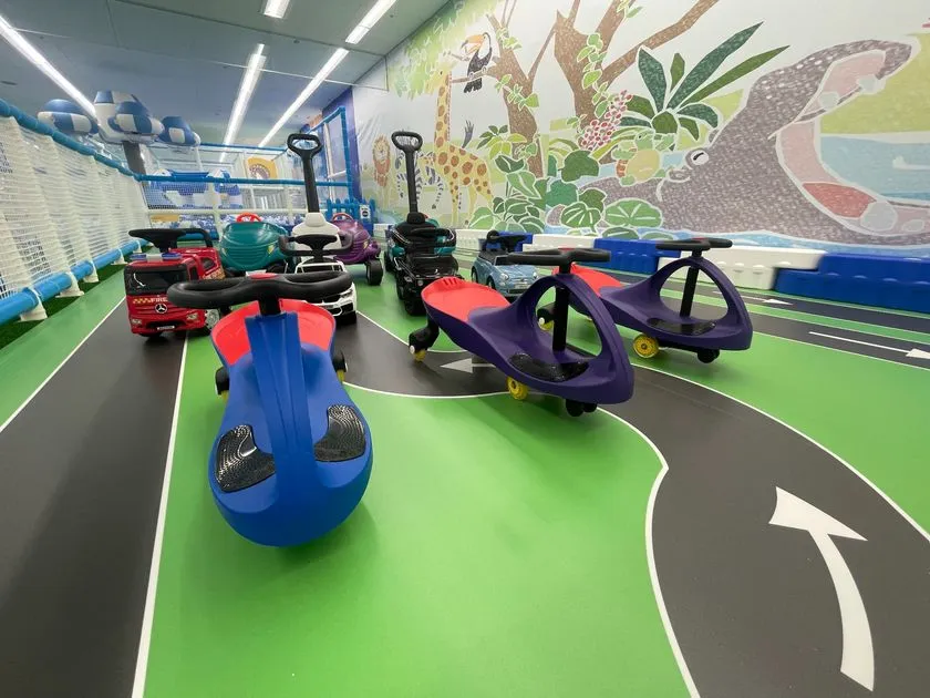 動物ジャングル壁画を背景に、メルセデスベンツ型やツイストカー型など複数の乗用玩具が並ぶカートコーナー
