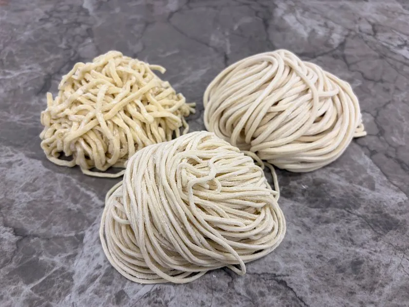さまざまな太さと食感の麺が並ぶ製麺の様子。細麺から太麺まで多様な麺種が揃う