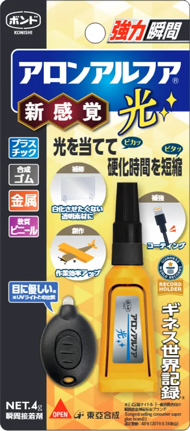 東亞合成のUV硬化瞬間接着剤「アロンアルフア 光」新感覚タイプの商品パッケージ。本体ボトルと専用UVライト（キーホルダー型）がセットで、プラスチック・金属など対応素材と硬化時間短縮の特長表記あり。ギネス世界記録ホルダーバッジ付き
