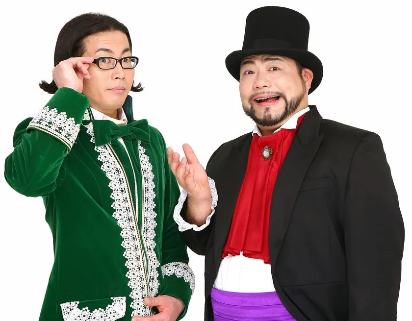 グリーンのベルベット衣装の男性とシルクハット・黒スーツの男性の2人組写真。イベントMCまたは出演芸人のプロモーションカット