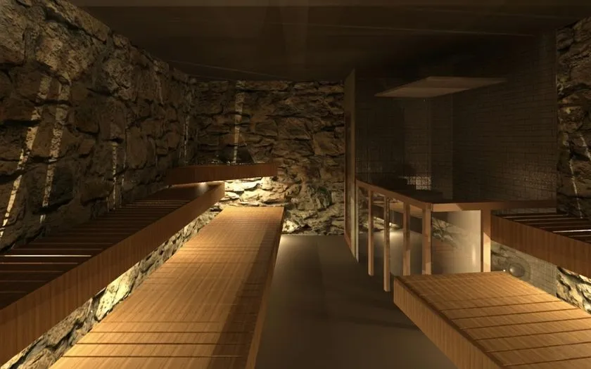 洞サウナ(DO SAUNA)の内部パース完成予想図。岩石積みの壁面と木製段状ベンチが左右に並ぶ洞窟型サウナ室の全景で、間接照明が演出する薄暗い空間構成がわかる