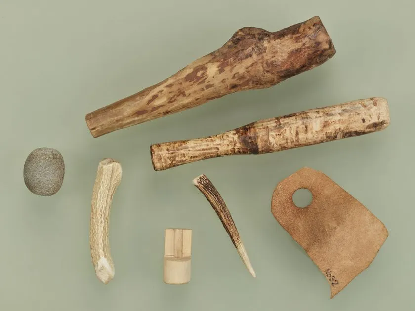 旧石器時代〜縄文時代初期の石錘・鹿角製品・骨角器・穿孔石器など7点の道具類を俯瞰配置した資料写真