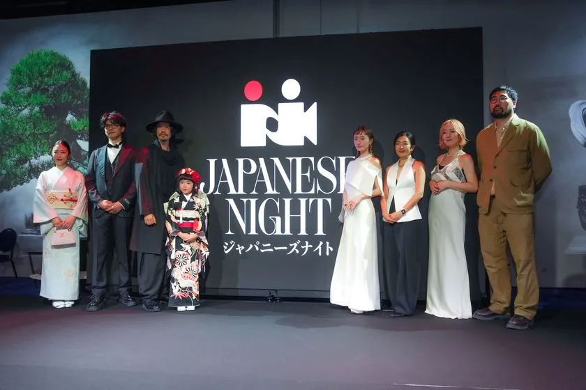 JAPANESE NIGHTロゴバックパネルの前に着物姿の女性2名・子ども1名とドレス・スーツ姿の出演者計8名が横一列に並ぶ集合写真