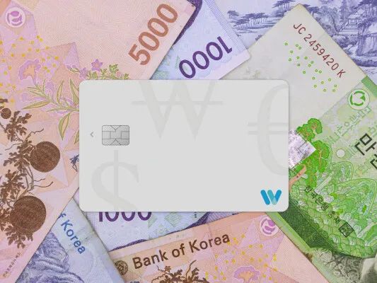 韓国ウォン紙幣（1000・5000・10000ウォン）を背景に、Travel WalletカードをICチップ面を上にして中央に置いたカード単体の商品イメージ写真。