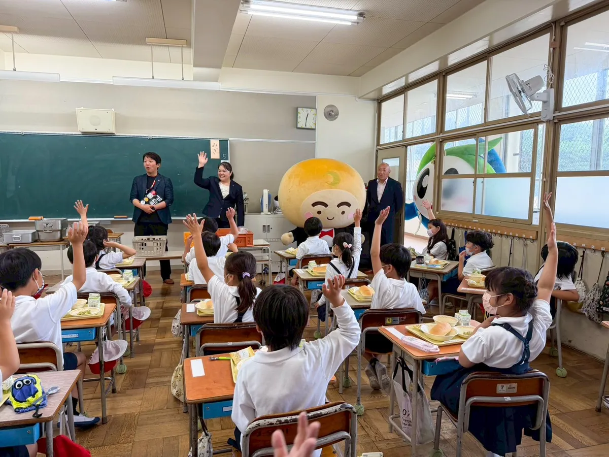 月化粧公式キャラクター「つきろーくん」が小学校を訪問している様子