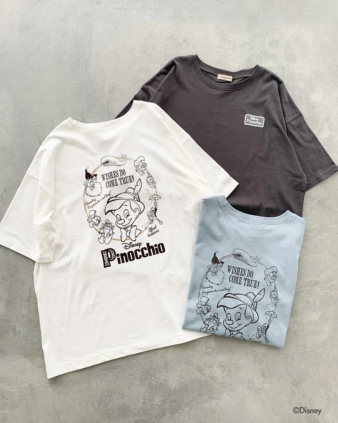 ピノキオと登場キャラクターを囲むサークルプリント入り半袖Tシャツ3色（ホワイト・チャコールグレー・ライトブルー）の表面デザインを示した商品ショット