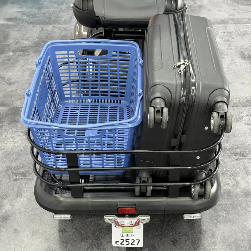 エレキャリーシリーズの後部荷台にブルーのプラスチックかごとスーツケースを積載した状態を真上から撮影、江東区ナンバープレート「E2527」も確認できる積載能力訴求ショット