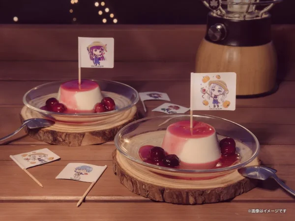 葬送のフリーレンコラボのメルクーアプリン2個を木製コースターに並べた全体ショット。赤いベリーソースとチェリー添え、各プリンにキャラクターデザインの旗刺し、背景にランタンとボケたイルミネーション