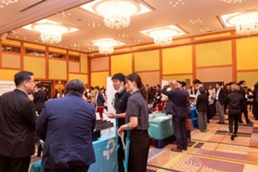 HOTERES EXPOの展示会場内フロア写真。複数の出展ブースにスタッフが立ち、スーツ姿の来場者が担当者と対面で商談・説明を受けている様子を撮影した会場内光景