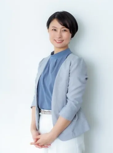 講師・道園亜希氏のプロフィール写真。グレーのジャケットと青いトップスを着用した助産師・包括的性教育講師の女性が白背景で正面を向いて微笑んでいる上半身ポートレート。