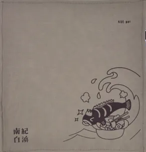 クエ鍋デザインのハンカチ：王冠をかぶったクエが鍋に入った姿が描かれている