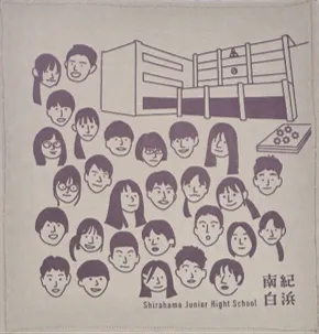 白浜中学校デザインのハンカチ：デザインを手がけた生徒たちの似顔絵と白浜中学校の校舎が描かれている