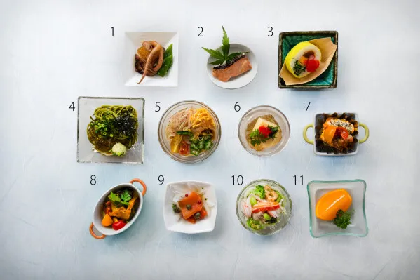 夏限定朝食メニューの11品を番号付きで並べた料理俯瞰写真。冷製前菜・煮物・ゼリー寄せ・オレンジ仕立てデザートなど各小鉢の品目構成が一覧できる