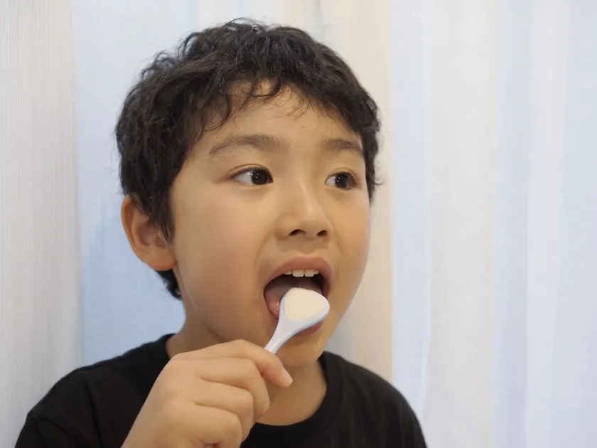 子どもが舌ブラシで舌ケアをしている様子