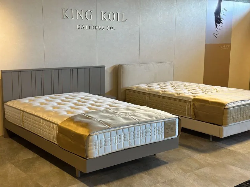 KING KOILのロゴ壁面前のベッドとマットレス展示