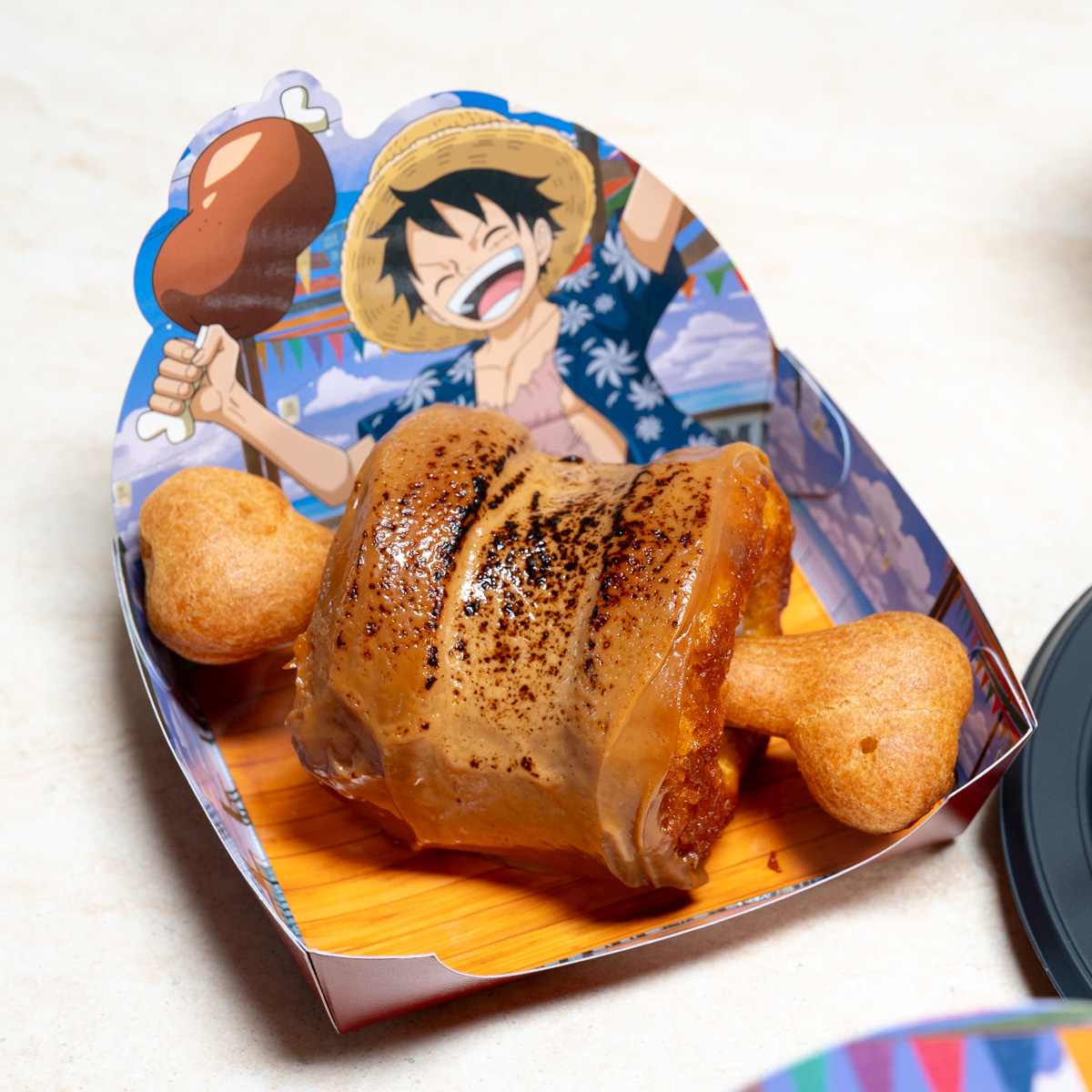 炙りの焦げ目が入ったキャラメル色のコーティングと骨形の焼き生地のデザート