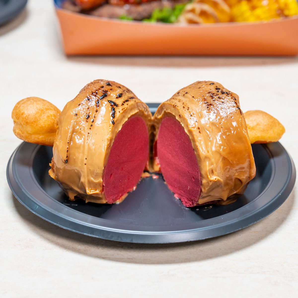 割ると濃い赤紫のムースが現れる骨付き肉型デザートの断面