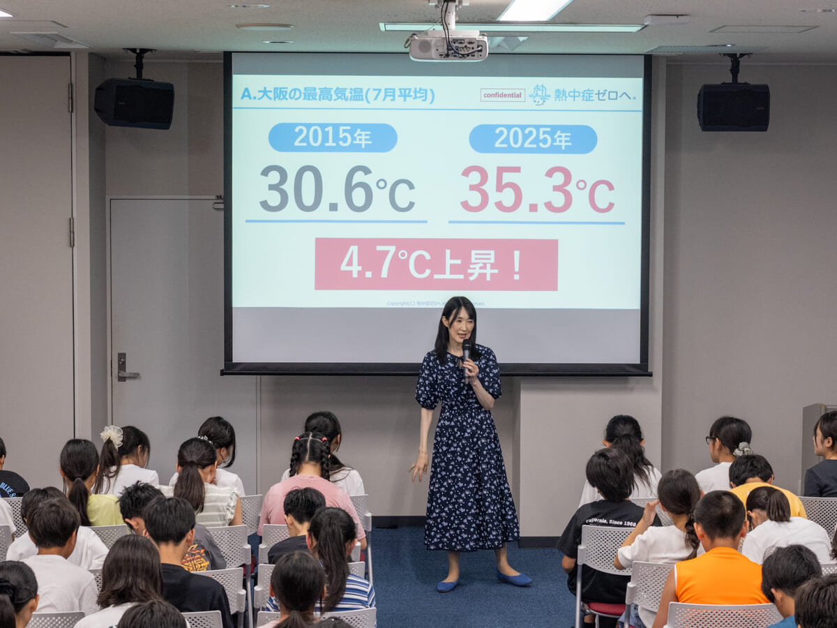 久保智子がスクリーン前で講義し、画面に大阪の最高気温が2015年30.6度から2025年35.3度へ4.7度上昇したと表示される様子