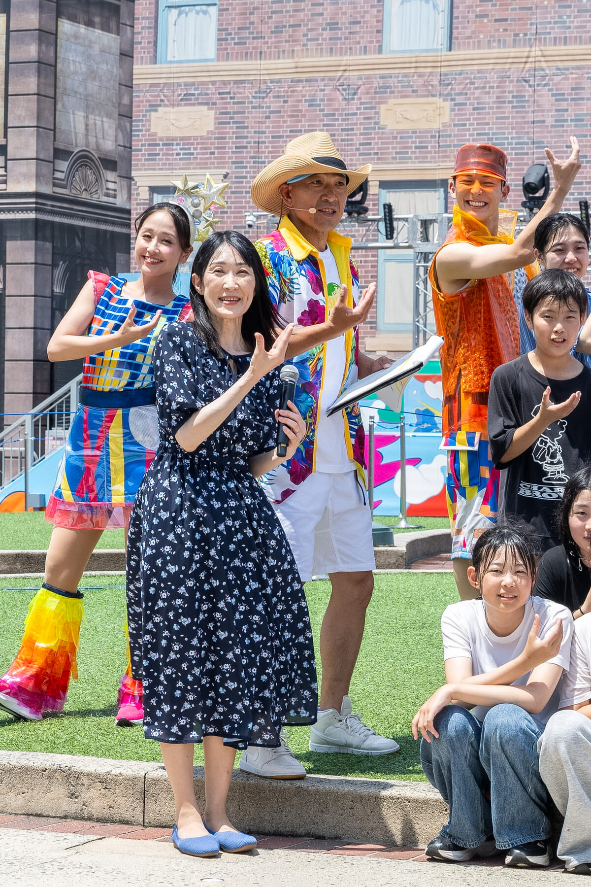 屋外ステージに久保智子と「綾小路麗華」、MC、エンターテイナー、子どもたちが並ぶエンディングの様子