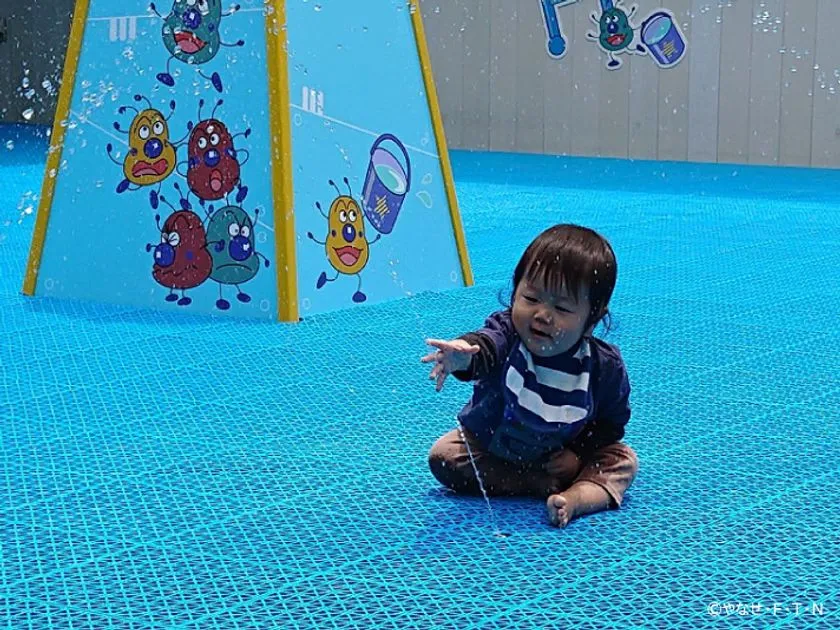 水流に手を伸ばす子ども