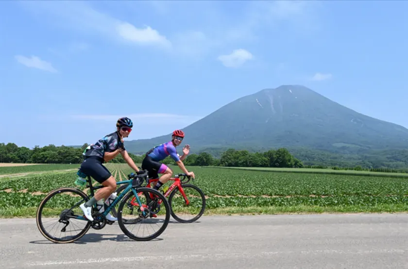 羊蹄山を望む道を走るサイクリスト