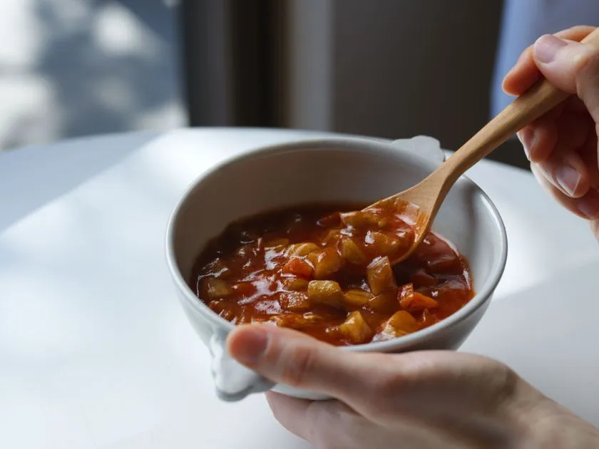 具材をすくう赤褐色スープ