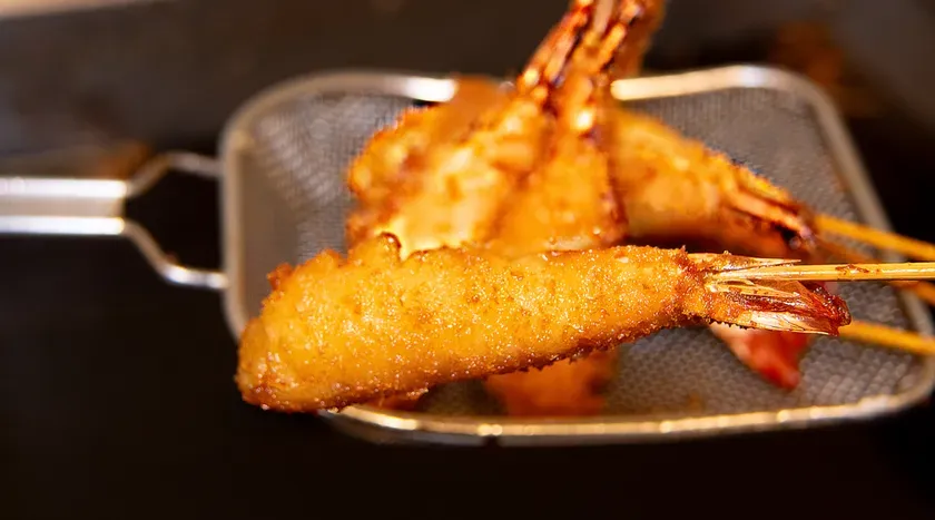 金網に盛ったエビ串揚げ