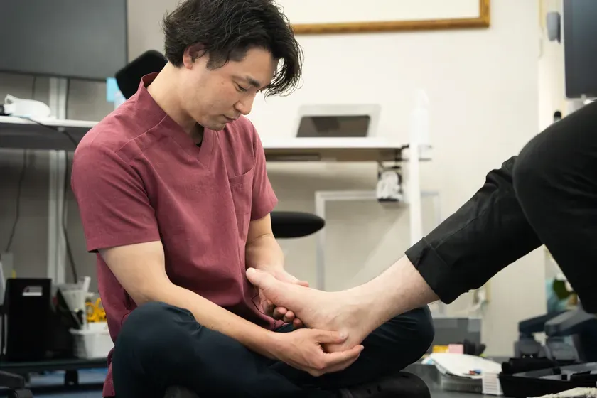 黒い医療用スクラブ姿の理学療法士・土屋元明氏