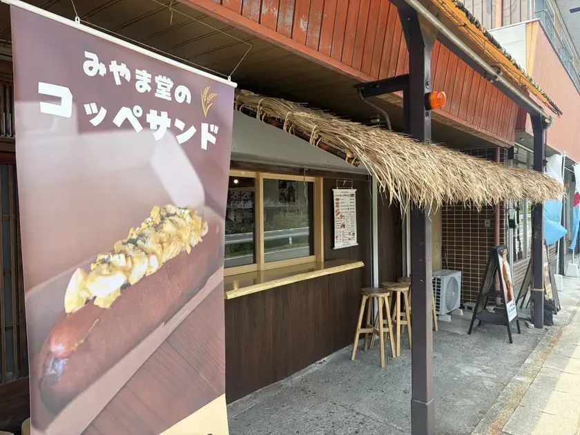 茅葺屋根の下に設けられた「みやま堂のコッペサンド」テイクアウトカウンターの外観