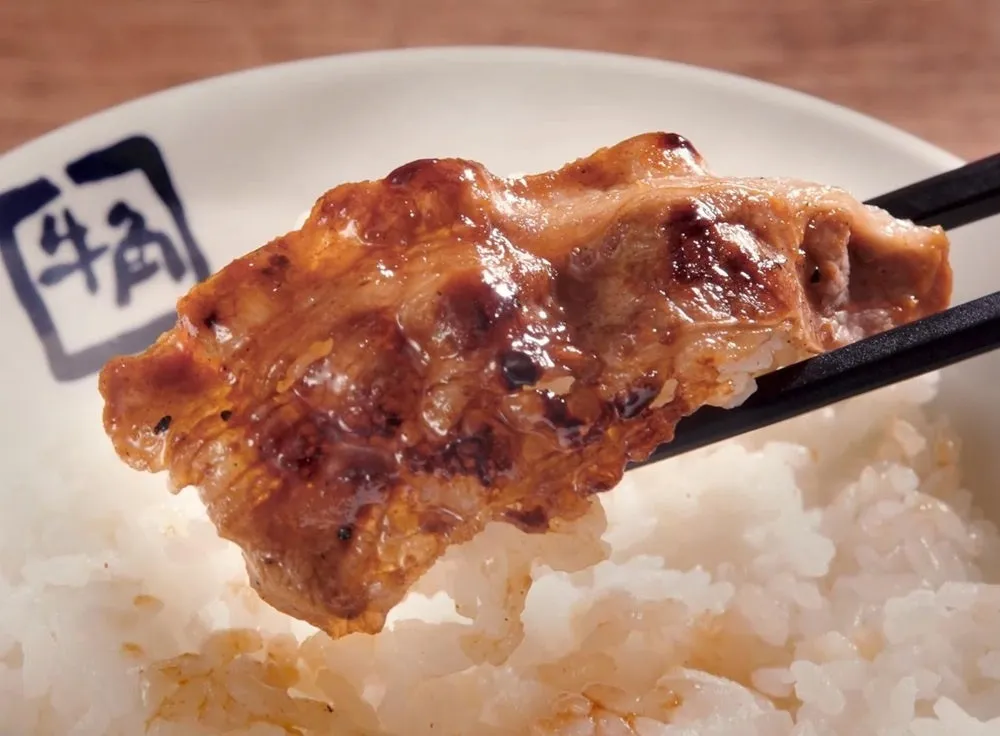 タレを絡めた月見牛カルビ焼肉定食のカルビ肉をご飯にのせるひと口