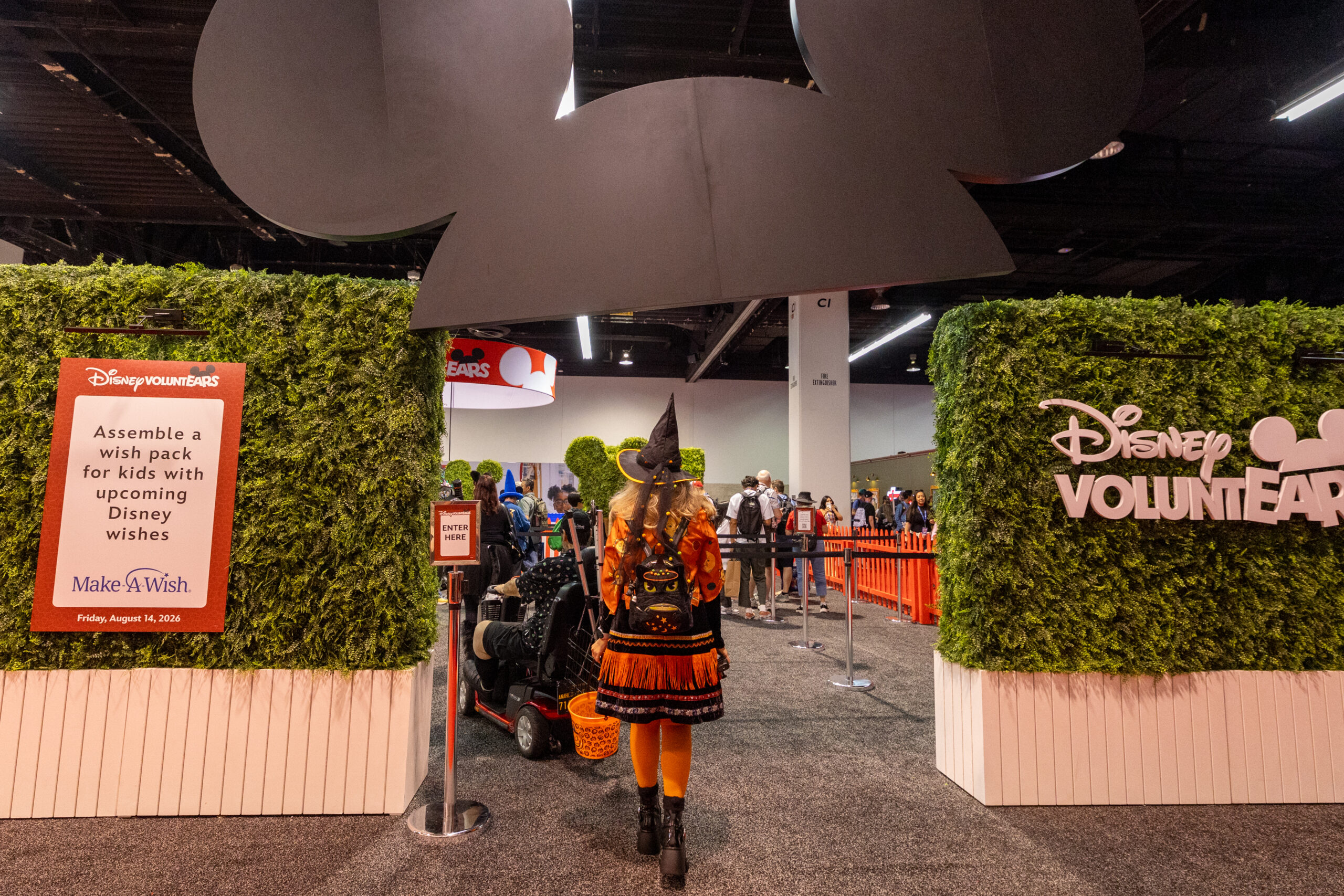 ミッキーの耳をかたどったアーチと案内サインが並ぶDisney VoluntEARSブースの入口