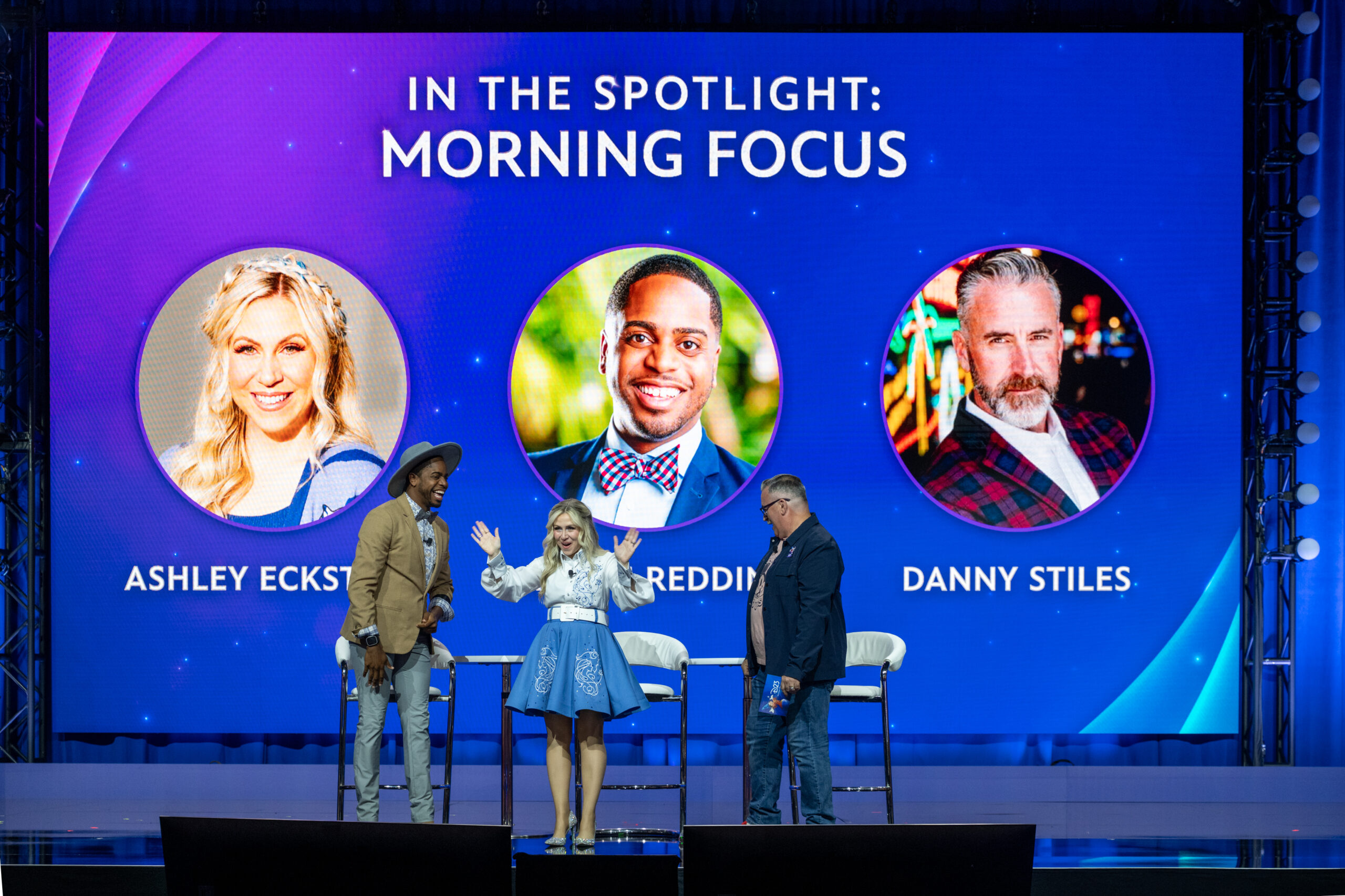 スクリーンに企画タイトルと登壇者3名の顔写真が並ぶIn the Spotlight: Morning Focusのステージ