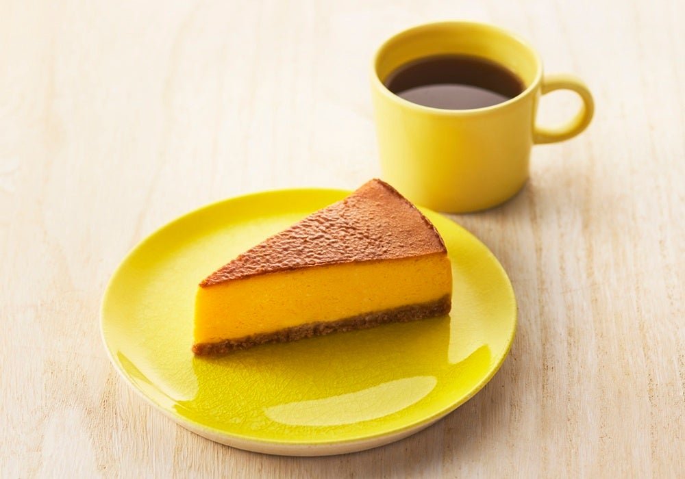 黄色い皿にのせたシナモンパンプキンチーズケーキとコーヒー