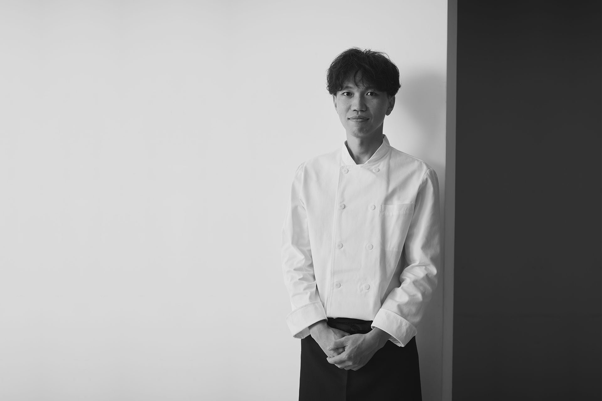 白いコックコート姿のシェフパティシエ 金井理仁さん