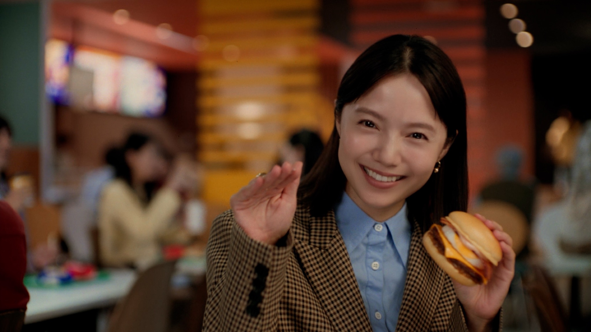 店内でバーガーを手に微笑む宮﨑あおいさん