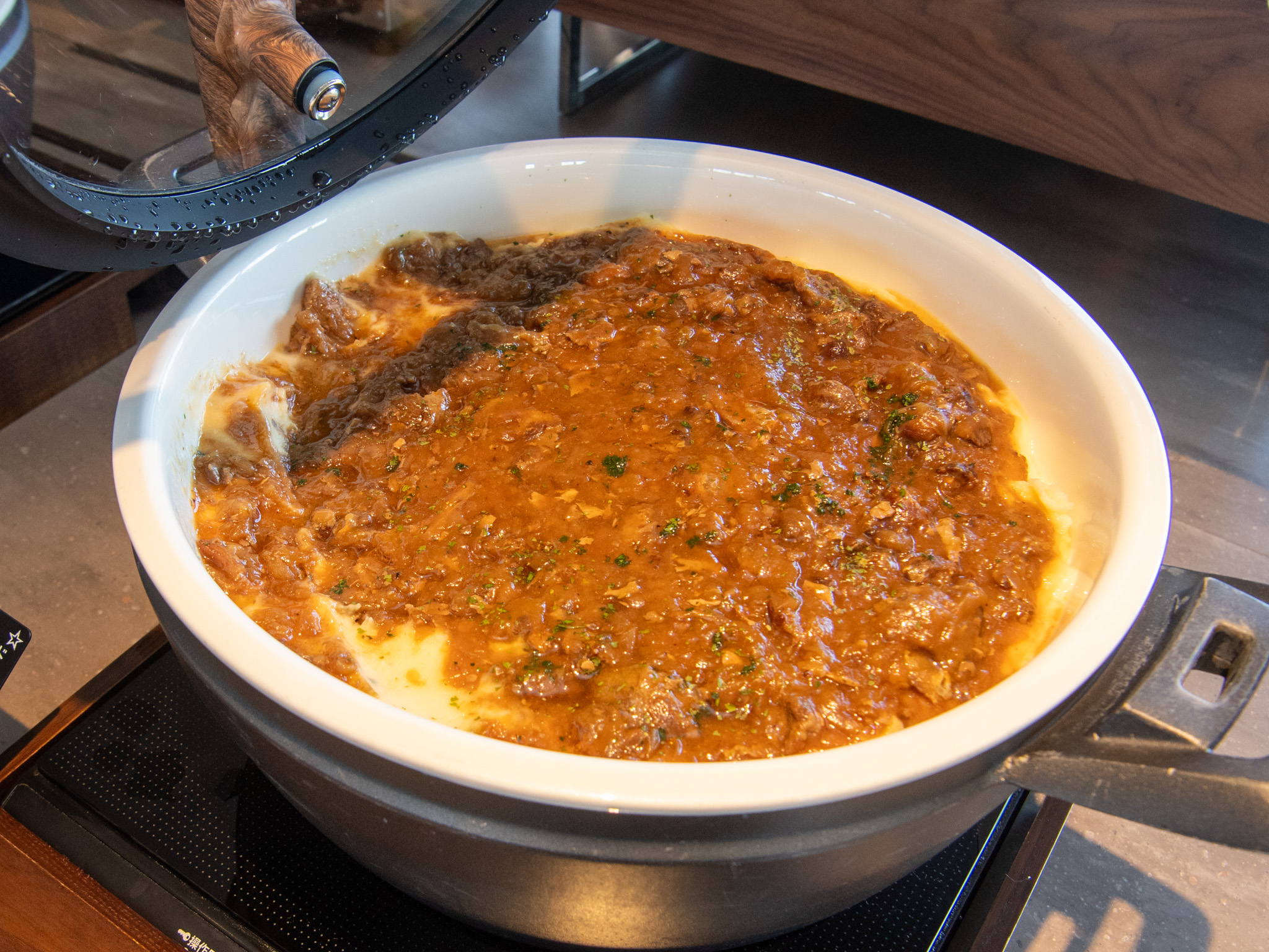 白い土鍋で煮込まれた牛肉の黒糖カルボナード